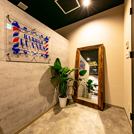 札幌の高級理容室「BARBER LUANES」のエントランスにある鏡と観葉植物が映えるおしゃれな空間